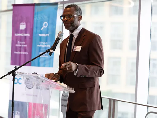 Elliott L. Ferguson, II speaking at a podium in a dark colored suit.
